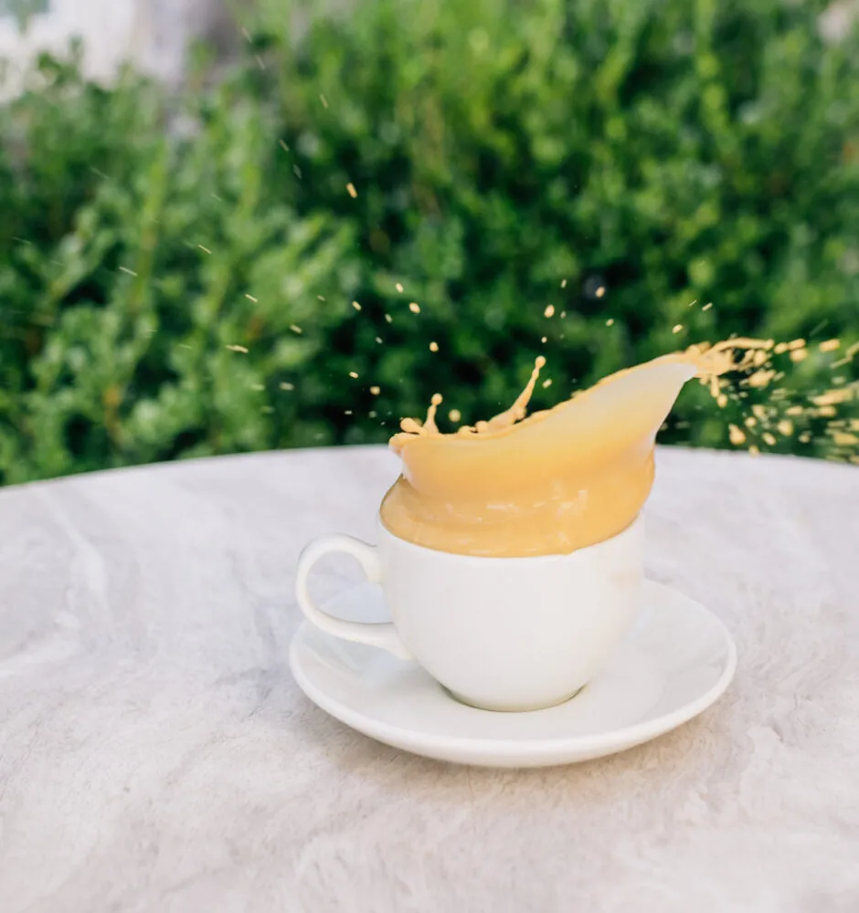 Coffee cup with foam splash on table
