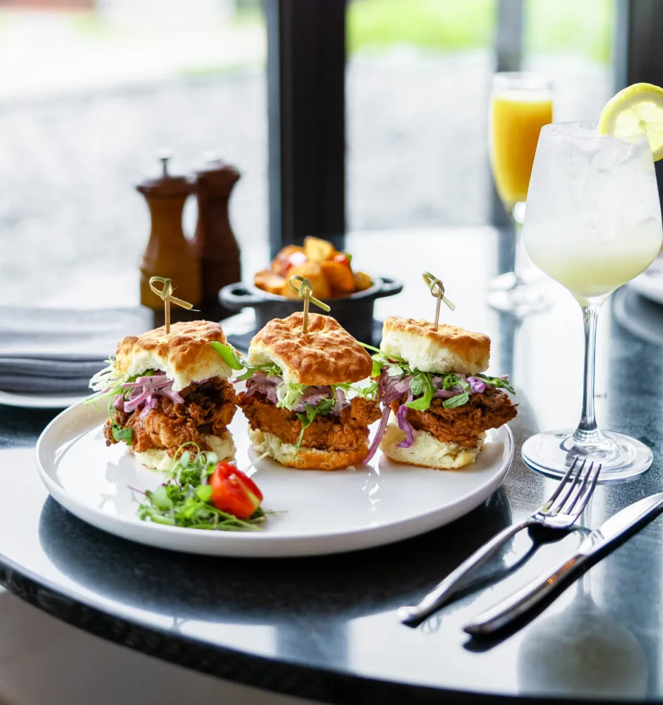 Plate of sliders with salad on restaurant table