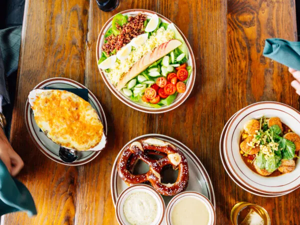 An overhead shot of several bowls of food on a wooden table.