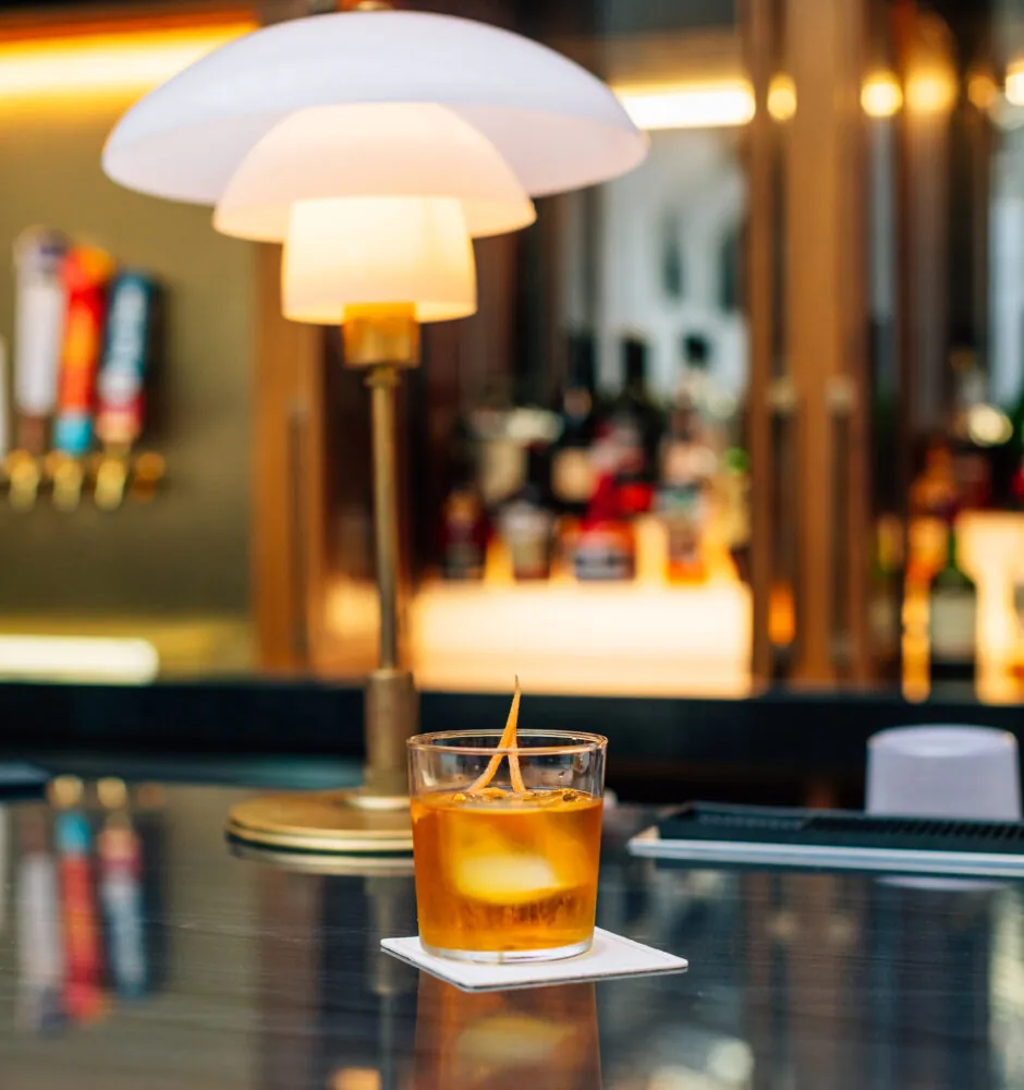 Whiskey cocktail on bar counter with lamp