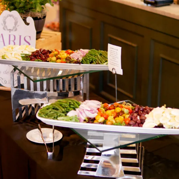 A buffet table with various foods arranged on white platters.