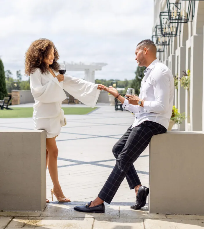 Couple dressed stylishly talking outdoors by hotel terrace
