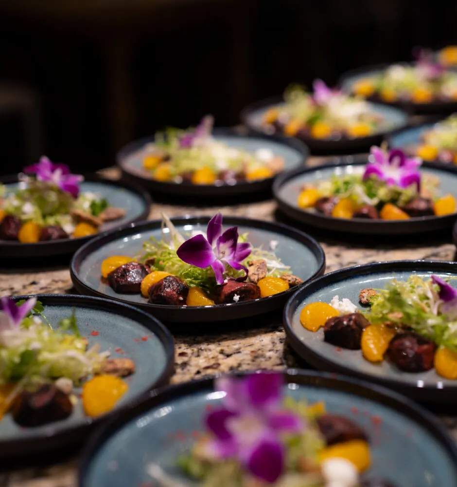 Multiple plates of gourmet salads with edible flowers
