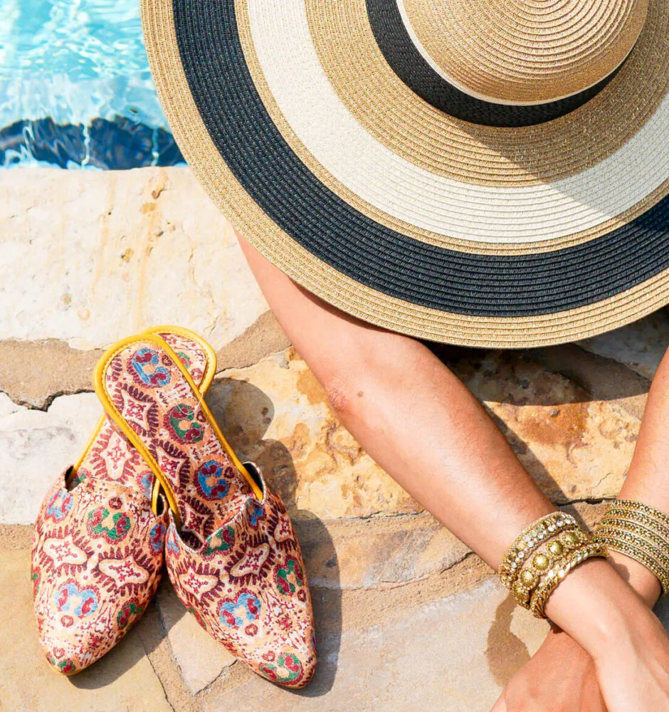 Woman in wide-brim hat relaxing at poolside