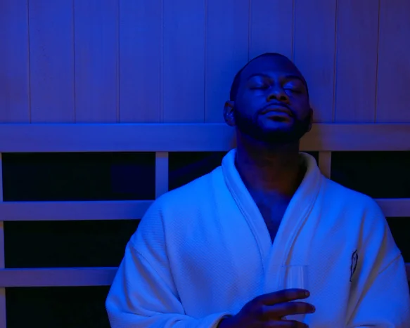 Man relaxing in a sauna wearing a robe