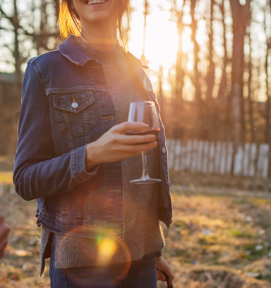 People holding wine glasses outdoors at sunset